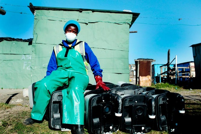 Photo of worker sitting with portable toilets