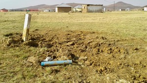 Photo of open land with a village in the distance