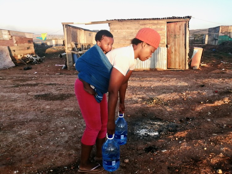 Photo of a woman carrying water containers