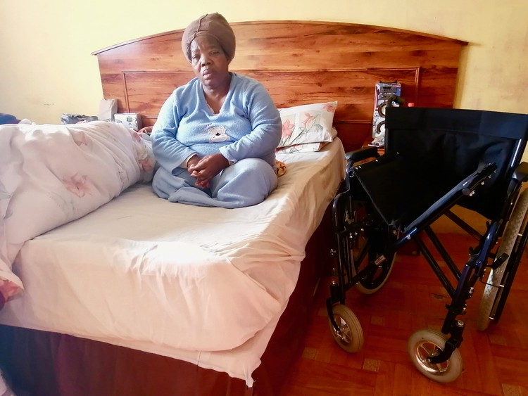 Photo of a woman sitting on her bed