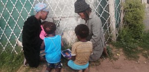 Photo of family kneeling with photo of child