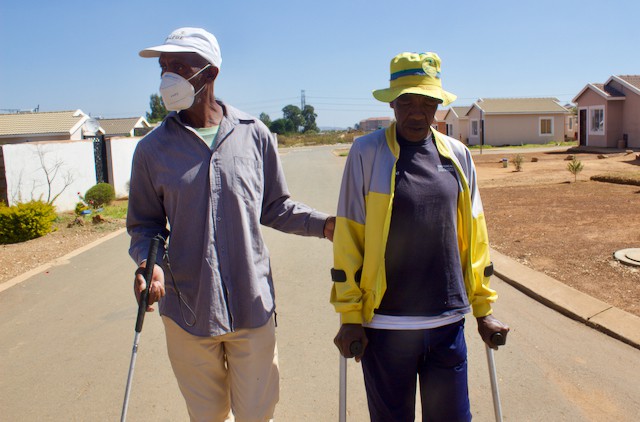 Photo of two people walking with sticks