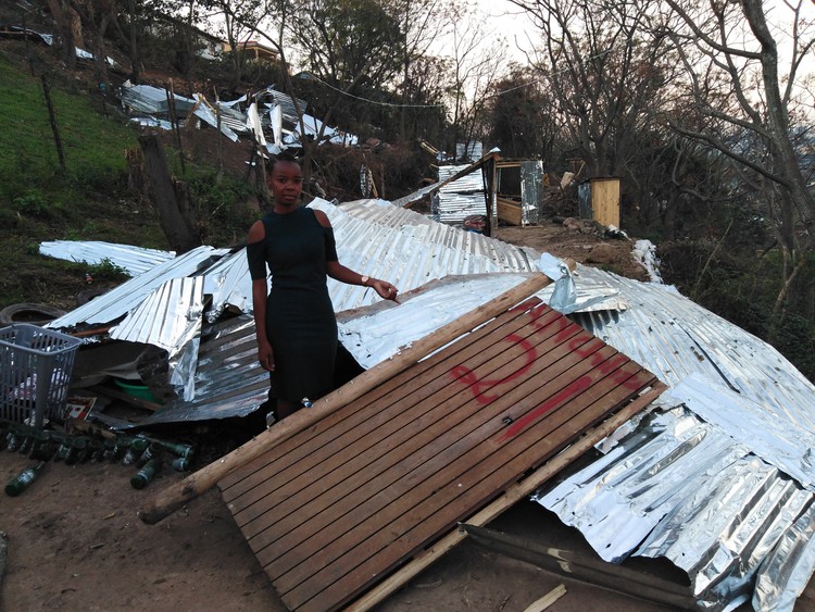 Photo of woman next to shack