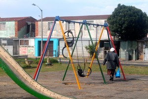 Photo of woman walking past derelict park in Lavender Hill