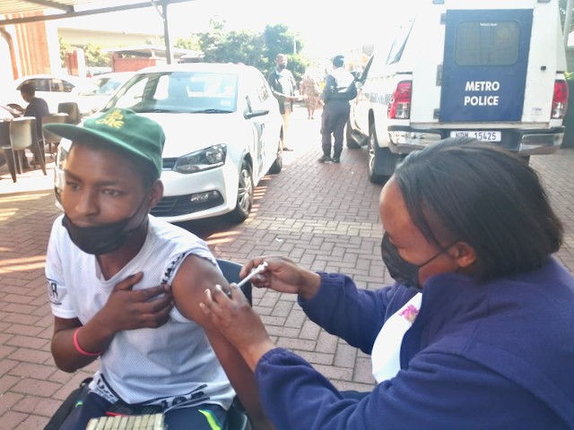 Photo of a young man being vaccinated