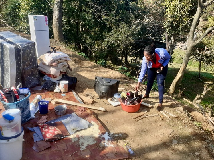 Photo of a woman and her demolished home