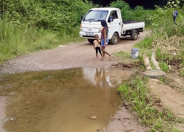 Photo of a stream running across a gravel road