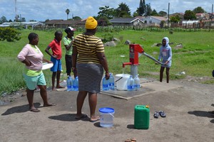 Photo of people at water pump