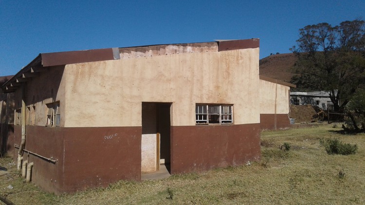 Photo of building with people\'s beds on the lawn