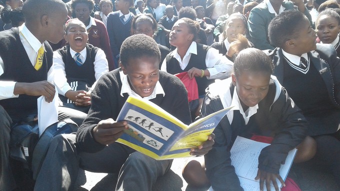 Photo of students sitting on the ground