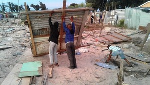 Photo of people building shacks