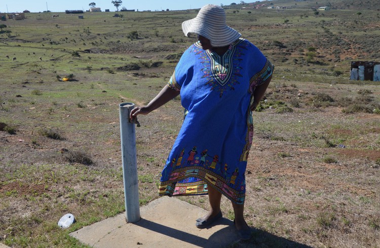 Photo of woman next to tap