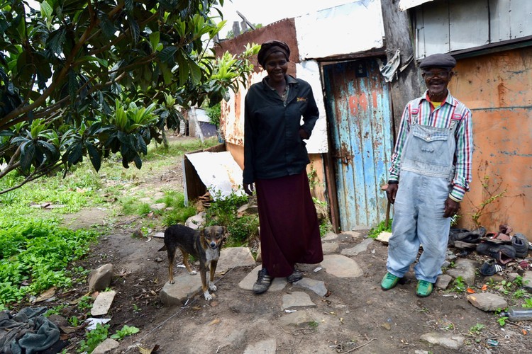 Photo of two people outside a shack