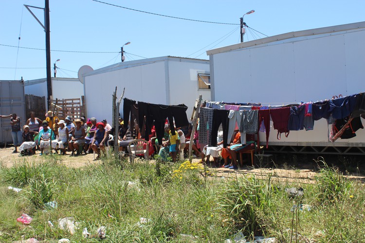 Photo of residents sitting outside their temporary homes