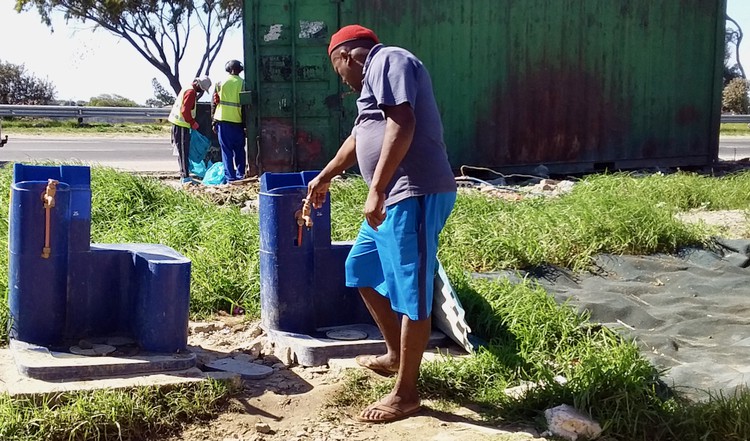 Photo of a communal tap and people