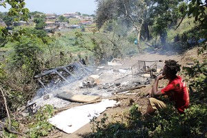 Phot of man watching home burning