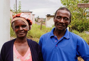 Photo of two people in front of house