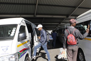 Photo of commuter climbing into taxi