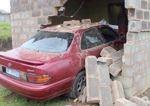 Photo of car broken through house wall