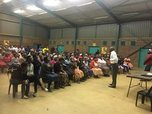 Photo of man addressing a crowd in a hall