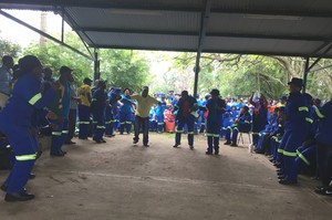 Photo of workers gathered in an open shed