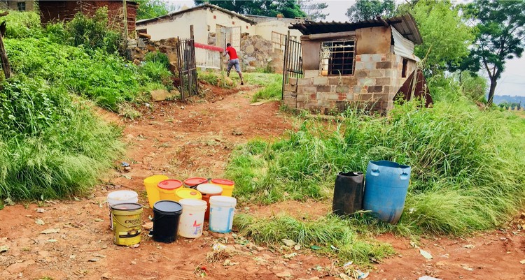 Photo of empty water containers outside a house