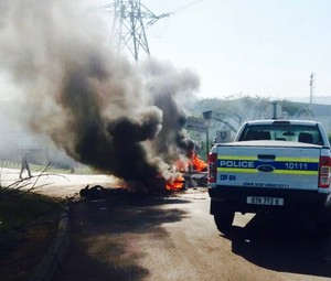 Photo of burning road  barricade and police vehicle