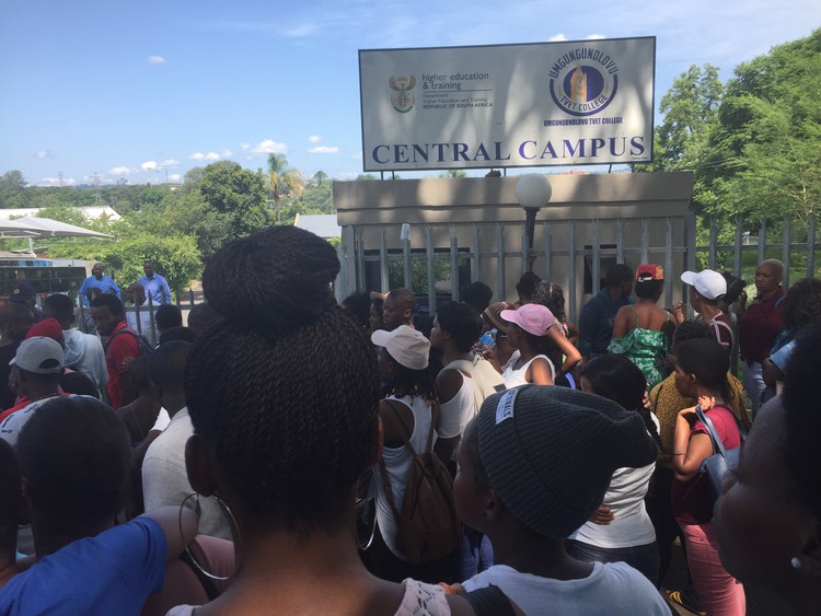 Photo of students outside the college\'s gates