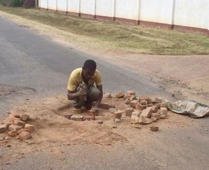 A man fixing a pothole