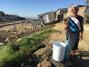 Photo of woman collecting water from standpipe