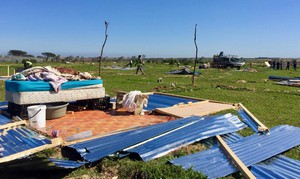 Photo of demolished shacks in a field