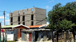 Photo of building with shacks in forefront