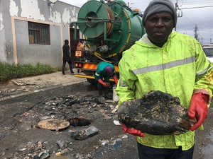 Photo of man in dirty clothes holding a rock