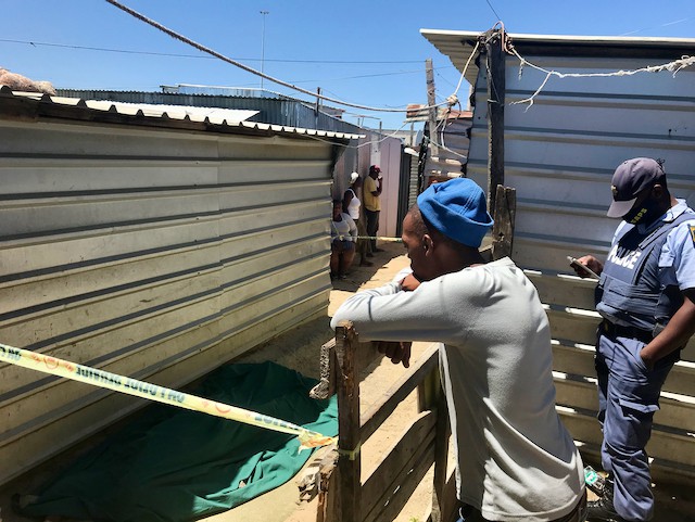 Photo of two men among shacks