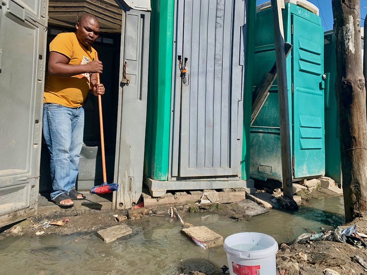 Photo of a man in a portable toilet