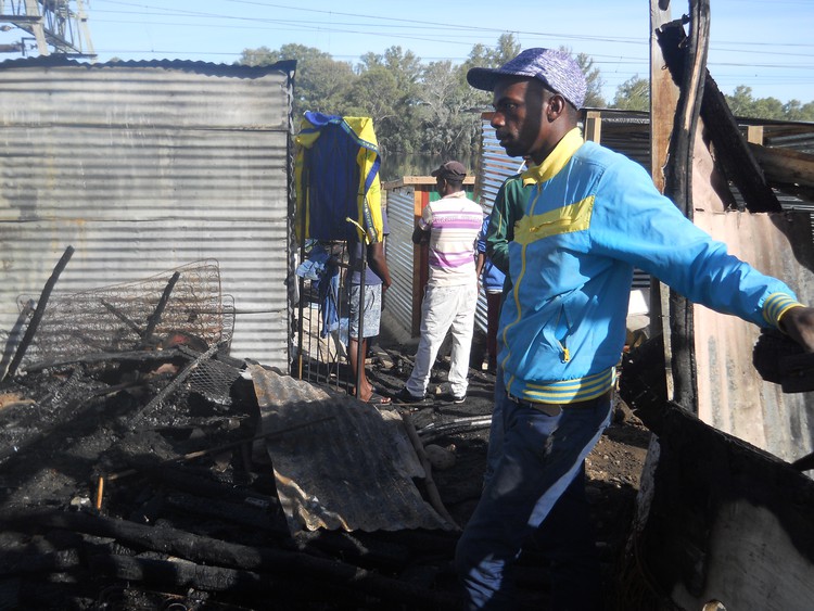 Photo of man at burned out shack