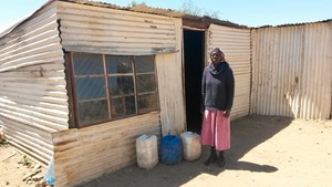 Photo of a woman and a shack