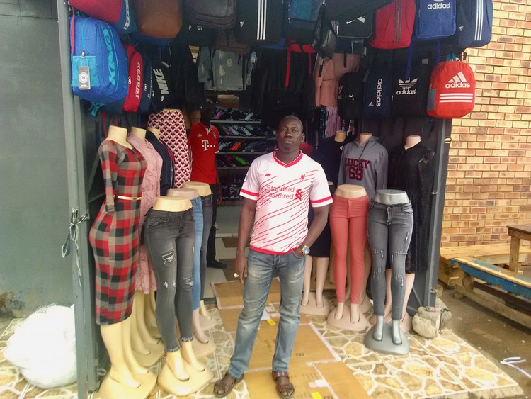 Photo of a man in front of his shop