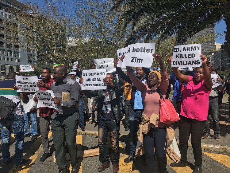 Photo of demonstrators holding placards