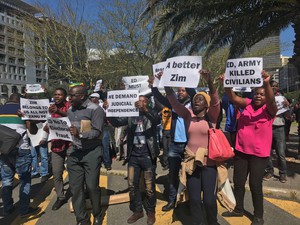 Photo of demonstrators holding placards