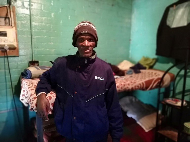 Photo of a man in a small room with a bunk bed