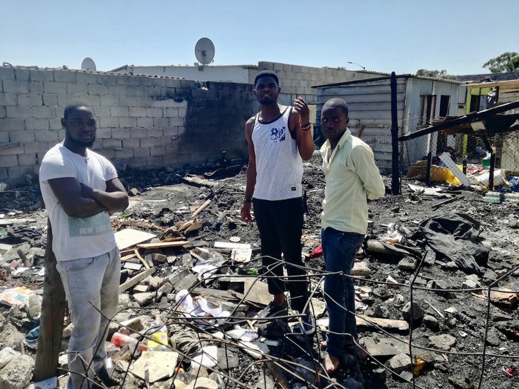 Photo of three men in burned ruins