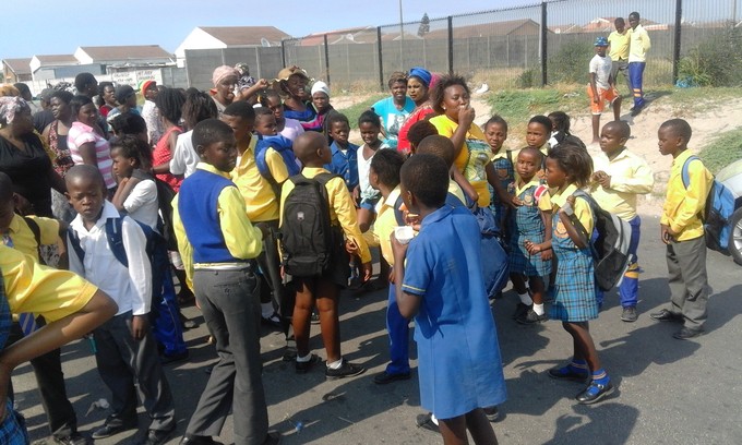 Photo of people standing outside school.