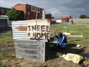 Photo of man rebuilding shack