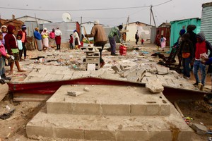 Photo of rubble and a crowd