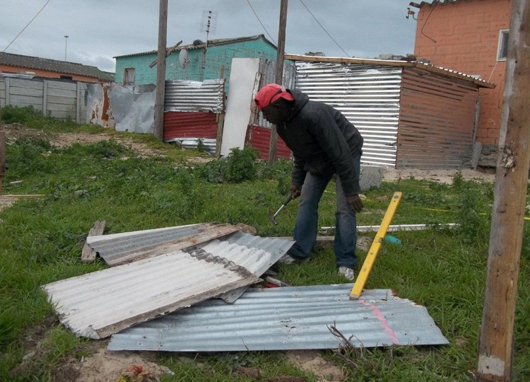 Photo of man building shack