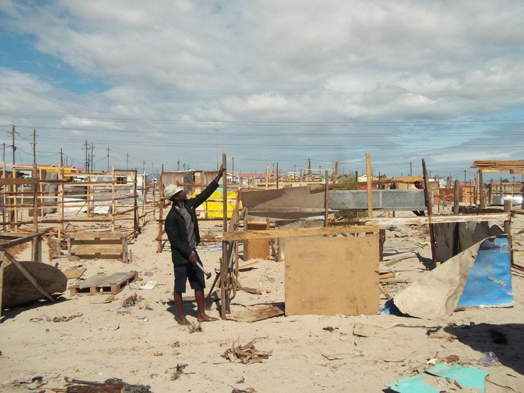 Photo of shack frames and a man