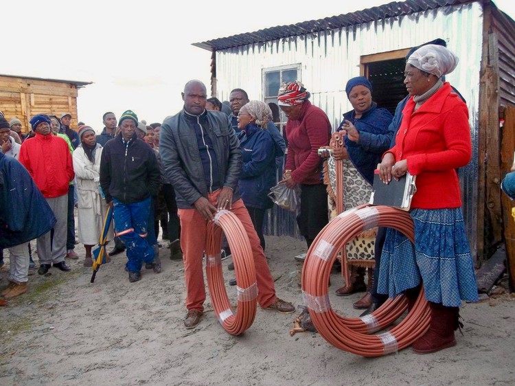 Photo of people with rolls of piping