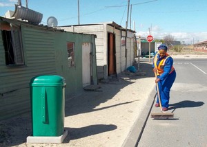 Photo of a woman sweeping a street