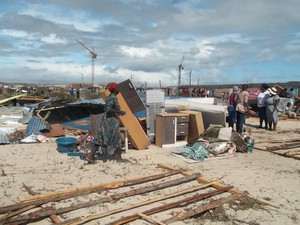 Photo of woman rushing by demolished shacks